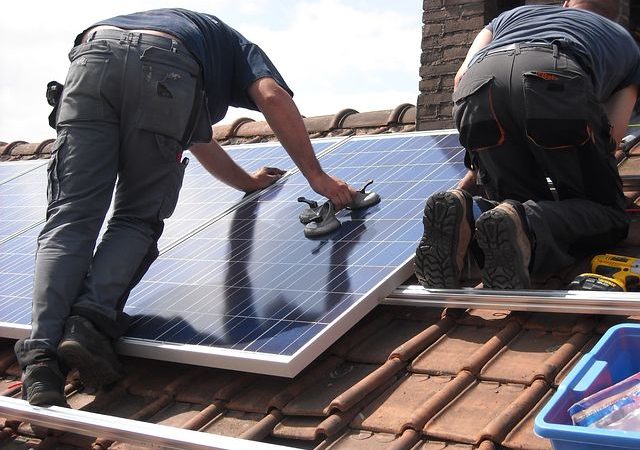 Two men installing commercial solar panels